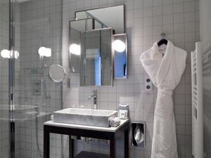 a white bathroom with a sink and a mirror at Hotel Saint Dominique in Paris +32 photos