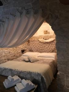 a bedroom with a bed in a stone wall at Trulli Aria di Casa in Alberobello