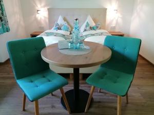 a dining room table with two chairs and a bed at Pension Claudia Zell am See in Zell am See