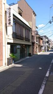 una strada vuota con un edificio sul lato della strada di Wajimaya Ryokan a Kyoto