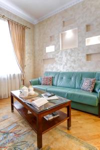 a living room with a green couch and a coffee table at Large EuApartments in Grodno