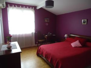 1 dormitorio con cama roja y ventana en A la Cerisaie, en Carignan