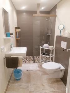 Łazienka z białą toaletą i umywalką w obiekcie Pension Claudia Zell am See w mieście Zell am See