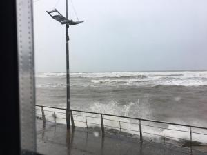 a view of the ocean from a window with a street light at B2 Waterfoot Apartment in Newcastle