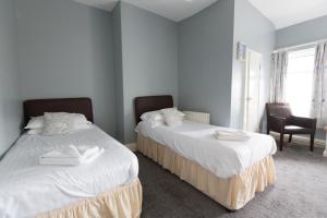 Un dormitorio con 2 camas y una silla. en Min y Mor Hotel, en Barmouth