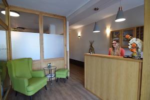 a woman standing at a reception desk in a room at Hotel Soudek in Poděbrady