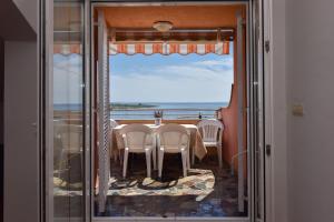a dining room with a table and a view of the ocean at Apartments Bella Sky V in Novalja