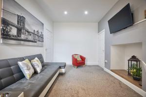 Host & Stay - Skyview في Seaton Delaval: غرفة معيشة مع أريكة رمادية وكرسي احمر