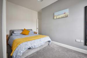 Host & Stay - Skyview في Seaton Delaval: غرفة نوم بسرير وبطانية صفراء