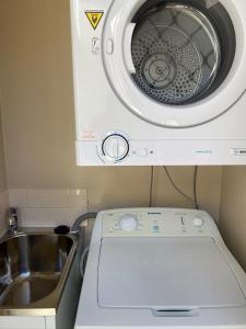 uma máquina de lavar roupa ao lado de um lavatório na cozinha em Acacia Terraces em Echuca