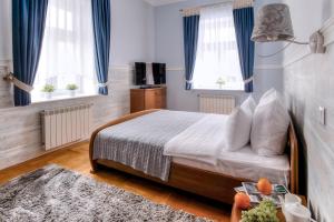 um quarto com uma cama e duas janelas com cortinas azuis em Large EuApartments em Hrodna