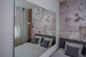 a bedroom with two beds and a brick wall at Republic Square Apartment - with garage in Novi Sad