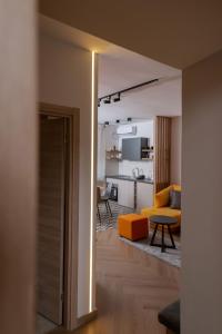 uma sala de estar com um sofá amarelo e uma mesa em Republic Square Apartment - with garage em Novi Sad