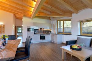 cocina y sala de estar con techo de madera en Appartement Erlenau en Ellmau