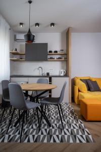uma cozinha e sala de jantar com mesa e cadeiras em Republic Square Apartment - with garage em Novi Sad