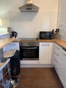 a kitchen with a microwave and a black oven at Durham Serviced Properties - The Sanctuary in Durham