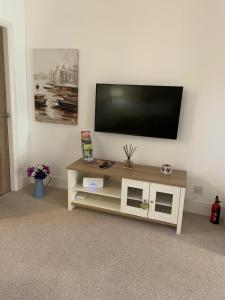 a flat screen tv sitting on top of a tv stand at Durham Serviced Properties - The Sanctuary in Durham