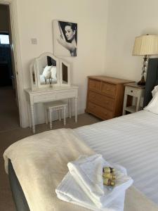 a bedroom with a bed and a table with a mirror at Durham Serviced Properties - The Sanctuary in Durham