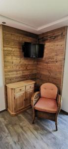 Zimmer mit einem Stuhl und einem TV an der Wand in der Unterkunft Pension Landhaus Riedelstein in Drachselsried