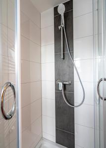a shower with a shower head in a bathroom at Hotel Restaurant Schwert in Kehl am Rhein +61 photos