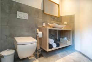 a bathroom with a white toilet and a sink at Mountain Living Ski-in & Ski out Silvretta Sommer Card Including in See +28 photos