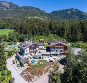 an aerial view of a resort with mountains in the background at Hotel Waldrast Dolomites in Siusi