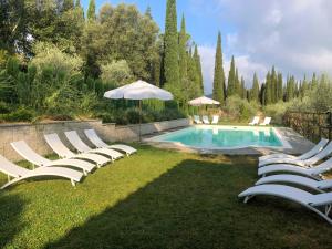 un gruppo di sedie a sdraio e un ombrellone accanto alla piscina di "Alle Montanine" Sughera a Firenze