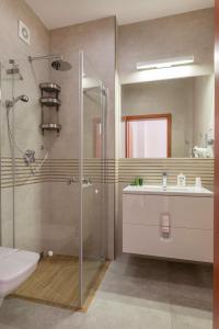 a bathroom with a shower, toilet and sink at Hotel Verde Montana Wellness & Spa in Kudowa-Zdrój
