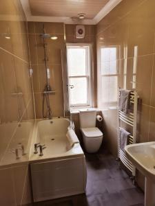 a bathroom with a tub and a toilet and a sink at Royal Victoria House in Dundee