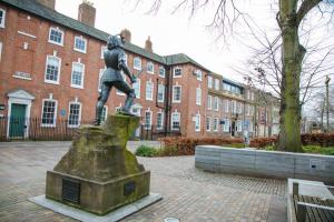 a statue of a man sitting on top of a statue at Contemporary Apartment in Leicester