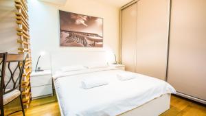 Un dormitorio con una cama blanca y una pintura en la pared en Luxury Apartment Bucharest Mall area, en Bucarest