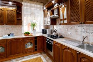 a kitchen with wooden cabinets and a sink at Large EuApartments in Grodno