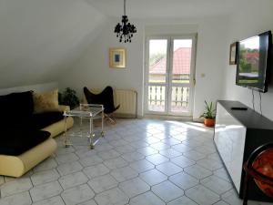 ein Wohnzimmer mit einem Sofa und einem Tisch in der Unterkunft Pension Nordseebriese in Dornum