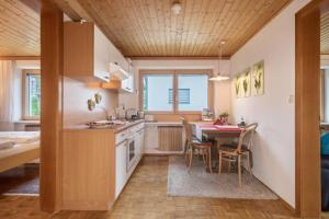 una cucina e una sala da pranzo con tavolo e sedie di Försterhaus Wohnung Obergeschoss a Egg