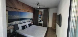 Schlafzimmer mit einem Bett und einem Deckenventilator in der Unterkunft Isabelle Apartament Alezzi Beach Resort Mamaia Nord in Mamaia Nord – Năvodari