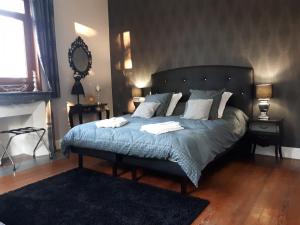ein Schlafzimmer mit einem Bett mit zwei Handtüchern darauf in der Unterkunft Le Manoir de la mantille in Caudry