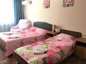 ゲレンジークにあるGolubaya Buhta "Kiparisovyi"のピンクのシーツとタオルが備わる客室内のベッド2台