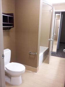 a bathroom with a toilet and a shower and a television at La Quinta by Wyndham Bellingham in Bellingham