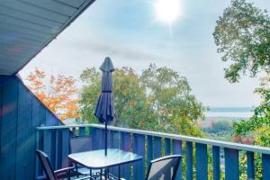 een tafel en stoelen op een balkon met een parasol bij Chalet Mont Sainte-Anne in Beaupré