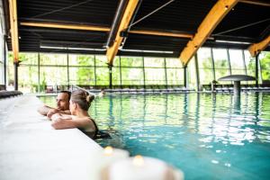 Ein Mann und eine Frau, die im Schwimmbad sitzen in der Unterkunft Hotel Terme Sveti Martin in Sveti Martin na Muri