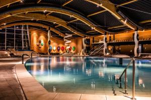 a large swimming pool in a building with an indoor swimming pool at Hotel Terme Sveti Martin in Sveti Martin na Muri