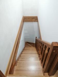 una escalera con barandillas de madera y paredes blancas en La morada del tio, en San Felices de los Gallegos