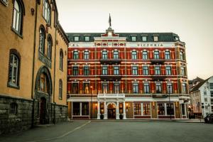 um grande edifício vermelho no meio de uma rua em Hotel Victoria em Stavanger
