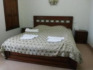 1 dormitorio con 1 cama con 2 toallas en Hotel Imperial 2011, en Yalta
