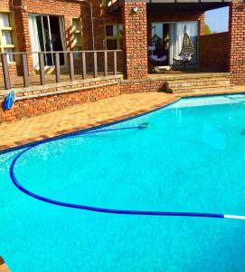 una gran piscina azul frente a una casa en Summer Vintage Home in Gonubie - just a Walk to the Beach!, en East London