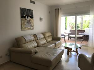 a living room with a couch and a table at Apartment Costalita, direct beach access, ground floor, salt water pool in Estepona