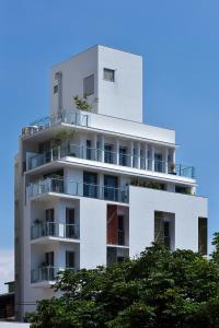 a white building with trees in front of it at Hotel Mapp in Taichung