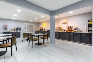 a restaurant with tables and chairs and a counter at Days Inn by Wyndham Granbury in Granbury