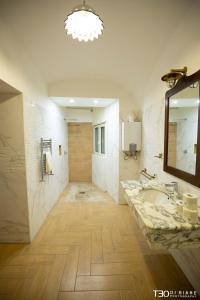 uma grande casa de banho com um lavatório e um espelho em La Loggia di Cassano by Dimorra em Nápoles