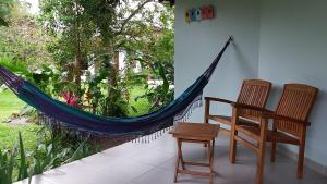 a room with a hammock and a chair and a table at Bangalôs Parque Verde in Paraty +3 photos